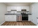 Bright kitchen showcasing stainless steel appliances, white cabinetry, and modern countertops at 744 Brittany Ct, Stone Mountain, GA 30083