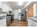Updated kitchen featuring stainless steel appliances, white cabinets, and hard wood floors at 744 Brittany Ct, Stone Mountain, GA 30083
