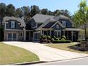 Charming two-story home featuring a spacious driveway, detailed trim, and manicured landscaping at 4960 Shade Creek Xing, Cumming, GA 30028