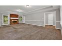 Spacious living room with a cozy brick fireplace and neutral carpet at 5309 Ashley Se Dr, Conyers, GA 30094