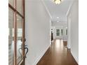 Inviting hallway featuring hardwood floors and elegant trim, leading to various rooms at 6265 Bellmoore Park Ln, Johns Creek, GA 30097