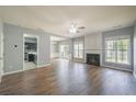 Open-concept living room with fireplace, wood flooring and large windows at 4205 Royal Regency Nw Cir, Kennesaw, GA 30144