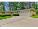 Single story home with a large driveway leading to a two car garage and well manicured front lawn at 4507 N Peachtree Rd, Dunwoody, GA 30338