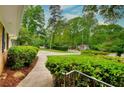 Beautifully landscaped front yard with lush greenery and a sidewalk leading to the home at 4507 N Peachtree Rd, Dunwoody, GA 30338
