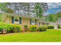 Charming brick home with well-manicured lawn and mature landscaping with blue shutters at 4507 N Peachtree Rd, Dunwoody, GA 30338