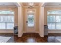 Inviting foyer with hardwood floors, arched windows, and decorative lighting fixture creates a warm welcome at 486 Raven Brook Ln, Suwanee, GA 30024