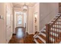 Beautiful hallway featuring hardwood floors, stairs, modern lighting fixtures and a glimpse of a half bathroom at 486 Raven Brook Ln, Suwanee, GA 30024