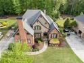 An aerial view of a landscaped two-story home with an expansive yard, driveway and mature trees at 1062 Meadow Grass Ln, Powder Springs, GA 30127