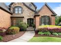Close-up of a home's inviting front entrance, featuring stone accents, a walkway, and colorful landscaping at 1062 Meadow Grass Ln, Powder Springs, GA 30127