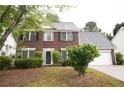 Charming two-story red brick home with a two-car garage and a well-manicured lawn at 1120 Lake Lucerne Rd, Lilburn, GA 30047
