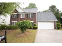 Charming two-story red brick home with a two-car garage and a well-manicured lawn at 1120 Lake Lucerne Rd, Lilburn, GA 30047