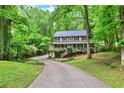 Charming two-story home featuring a welcoming front porch and surrounded by lush greenery, set back on a long driveway at 2253 Creekstone Ct, Marietta, GA 30062