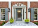 Elegant front entrance with a frosted glass door, sidelights, and decorative planters at 230 Seamarsh Ct, Atlanta, GA 30328