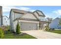 View of the house focusing on the spacious two-car garage, long driveway, and tidy landscaping at 351 Boundless Ln, Canton, GA 30114