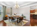 Formal dining room featuring a modern chandelier, large windows, and views into the kitchen at 5115 Edgebrook Dr, Cumming, GA 30040