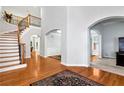 Elegant foyer with a curved staircase, hardwood floors, and arched doorways at 5309 Davenport Mnr, Cumming, GA 30041