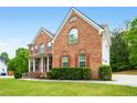 Beautiful brick home with manicured lawn and mature trees on a sunny day at 650 Virginia Highlands, Fayetteville, GA 30215