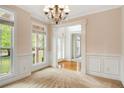 Bright living room featuring wainscoting, large windows, and a chandelier at 650 Virginia Highlands, Fayetteville, GA 30215