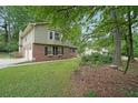 Side view of a two-story brick home showing the garage and well-kept lawn at 387 Cascade Sw Dr, Lilburn, GA 30047