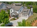 An aerial view of a pristine two-story home showcasing a brick and siding exterior, surrounded by verdant trees at 500 S Hill St, Buford, GA 30518