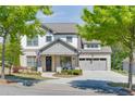 Beautiful two-story home featuring a brick and siding exterior, set amidst lush greenery and mature trees at 500 S Hill St, Buford, GA 30518