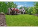 Expansive front yard leading to a light brick home with lush, mature trees surrounding the property at 7045 W Mountain Xing, Cumming, GA 30041