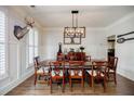 Elegant dining room with hardwood floors, wainscoting, and a modern chandelier at 7155 Hartsfield Pl, Suwanee, GA 30024
