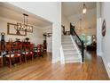 Spacious foyer featuring hardwood floors, staircase with black railings, and access to the dining and living areas at 7155 Hartsfield Pl, Suwanee, GA 30024