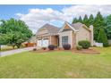 Charming single-story home featuring a well-manicured lawn, stone accents, and a two-car garage at 905 Downyshire Dr, Lawrenceville, GA 30044