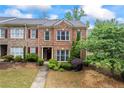 Beautiful brick townhome with manicured front lawn and traditional architectural details under a partly cloudy sky at 168 Constitution Blvd # 12, Lawrenceville, GA 30046