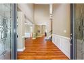 Grand entryway with beautiful hardwood floors, wainscoting, and decorative glass double doors at 4240 Hastings Dr, Cumming, GA 30041