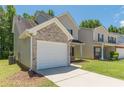 Side view of a two-story home showcasing the vinyl siding, brick accents, attached garage, and well-kept lawn at 5280 Tussahaw Xing, Mcdonough, GA 30252