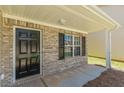 Close-up of front porch with black front door and brick accents with a single window at 5280 Tussahaw Xing, Mcdonough, GA 30252