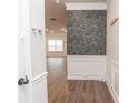 A stylish entryway featuring wood floors, elegant white wainscoting, and decorative wallpaper at 1024 Burke St # 56, Lawrenceville, GA 30046