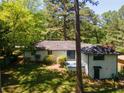 Exterior shot of a home's backyard featuring a small deck and lawn area with some landscaping at 2704 Terratim Ln, Decatur, GA 30034