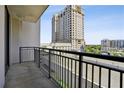 Balcony with black metal railings offering views of the surrounding city buildings and greenery at 3040 Peachtree Nw Rd # 713, Atlanta, GA 30305