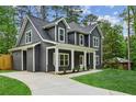 Beautiful two-story home with gray siding, white trim, and a spacious driveway in a wooded setting at 1347 Midlawn Dr, Decatur, GA 30032