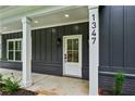 Close-up of the home's entrance with a white front door, brick base, and contemporary house number at 1347 Midlawn Dr, Decatur, GA 30032