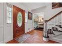 Inviting foyer featuring hardwood floors, elegant staircase, and decorative front door with stained glass at 5027 Castlewood Sw Dr, Lilburn, GA 30047