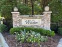Stone monument sign for The Wiltshire community, surrounded by lush landscaping and a wrought-iron fence at 3047 Lenox Ne Rd # 2105, Atlanta, GA 30324
