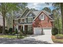 Charming two-story brick home with a well-manicured lawn, professional landscaping, and attached two car garage at 8640 Amsbury Way, Cumming, GA 30041