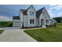 Beautiful two-story home with a white exterior, a driveway leading to a two car garage, and manicured lawn at 6490 Mockingbird Rd, Cumming, GA 30028
