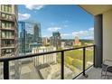 Relaxing balcony view with city buildings, clear blue skies, and metal framed seating for two at 1280 W Peachtree Nw St # 2801, Atlanta, GA 30309