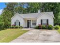 Quaint one-story home with a well-manicured lawn and blooming flower bushes at 25 Bridlewood Ct, Stockbridge, GA 30281