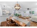 Open-concept dining area with modern lighting, wood floors, and seamless flow to the living room at 808 Casplan Sw St, Atlanta, GA 30310