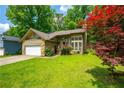 Charming single-Gathering home with a stone and siding exterior, well-manicured lawn, and a red maple tree at 1131 Bailing Dr, Lawrenceville, GA 30043