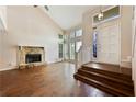 Open-concept living room with a stone fireplace, hardwood flooring, and large windows for plenty of natural light at 1131 Bailing Dr, Lawrenceville, GA 30043