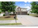Charming two-story home with a well-maintained lawn, mature trees, and a spacious driveway at 5760 Palmtree Pass, Cumming, GA 30040
