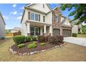 Attractive home featuring a manicured lawn, stone accents, and a welcoming front porch at 5760 Palmtree Pass, Cumming, GA 30040