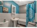 Bathroom featuring white tile, pedestal sink, and blue accent wall at 2004 Poplar Falls Rd, Lithonia, GA 30058
